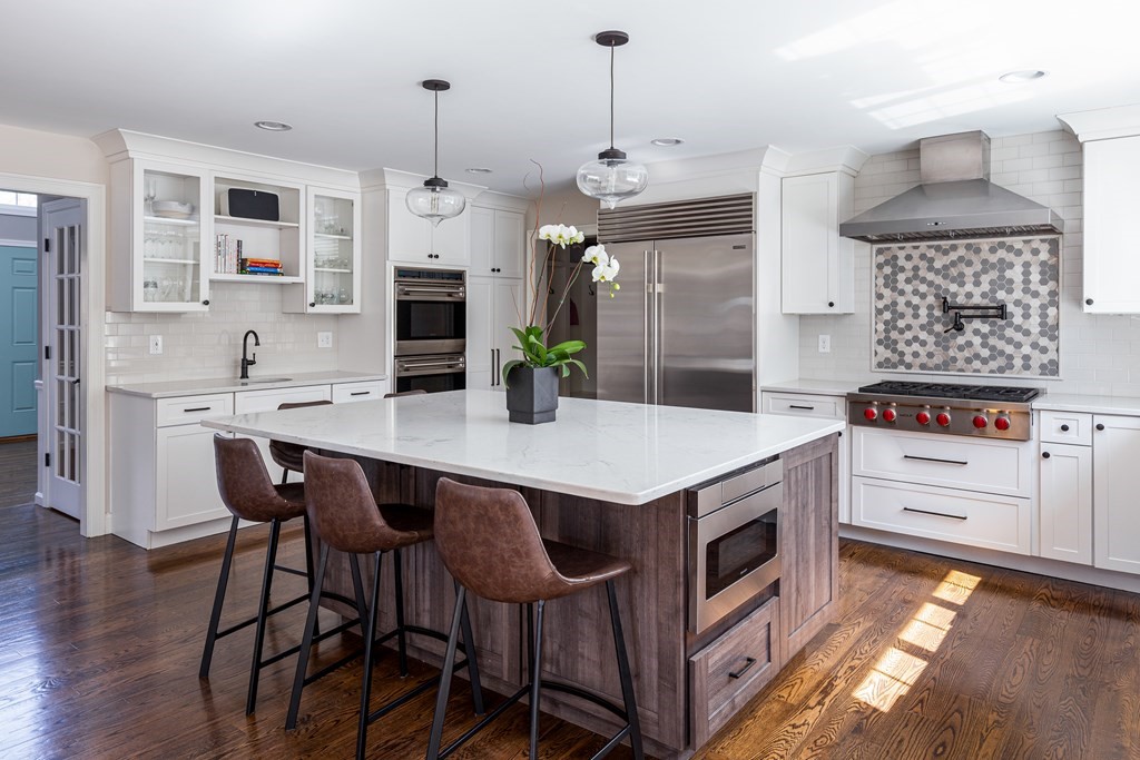 23 Pennock Road Ashland, MA 01721 - Photo 17 of 41 a kitchen with a stove a refrigerator and a dining table with wooden floor