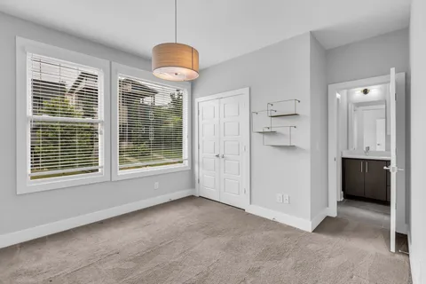 a view of an empty room with a window and a kitchen