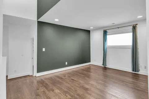 a view of an empty room with closet and a window