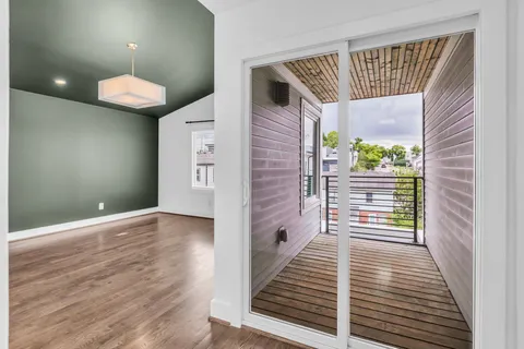a view of a hallway with wooden floor and a chandelier