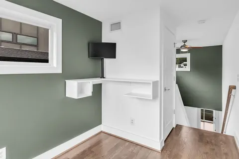 a view of a livingroom with wooden floor and cabinet