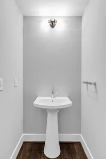 a bathroom with a sink a mirror and wooden floor