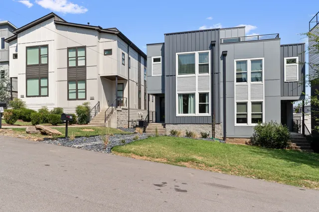 a front view of a house with a garden and plants