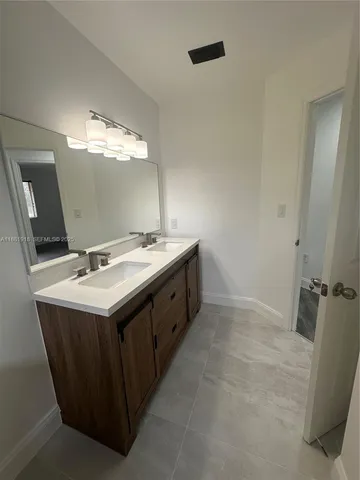 a bathroom with a double vanity sink toilet mirror and bathtub
