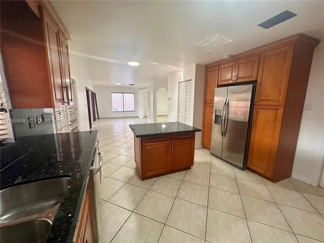 a large kitchen with granite countertop a stove a sink dishwasher and a refrigerator