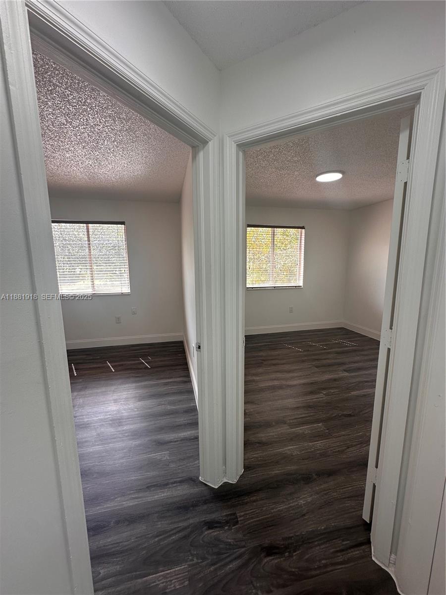 8950 Northwest 189th Terrace Hialeah, FL 33018 - Photo 22 of 42 a view of an empty room with wooden floor and a window
