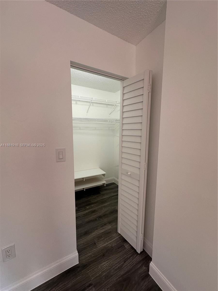 8950 Northwest 189th Terrace Hialeah, FL 33018 - Photo 25 of 42 a view of walk in closet with wooden floor
