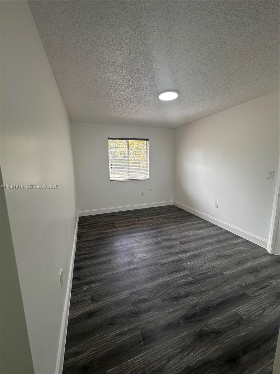 8950 Northwest 189th Terrace Hialeah, FL 33018 - Photo 26 of 42 an empty room with wooden floor and windows