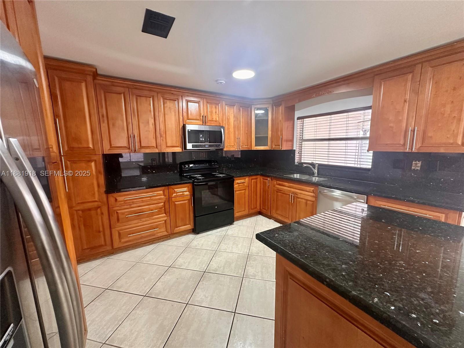 8950 Northwest 189th Terrace Hialeah, FL 33018 - Photo 3 of 42 a kitchen with stainless steel appliances granite countertop a sink stove and cabinets