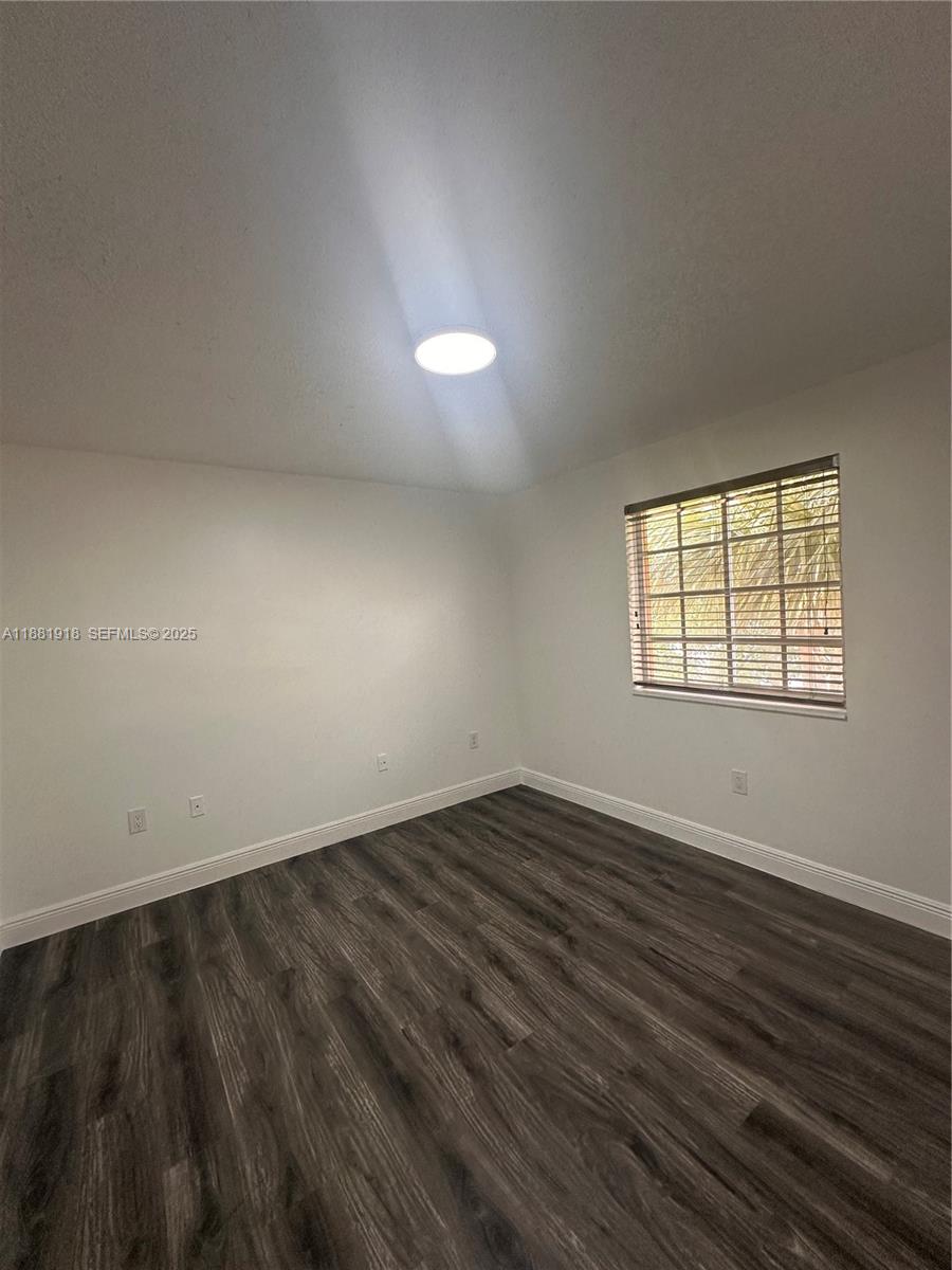 8950 Northwest 189th Terrace Hialeah, FL 33018 - Photo 33 of 42 an empty room with wooden floor and windows