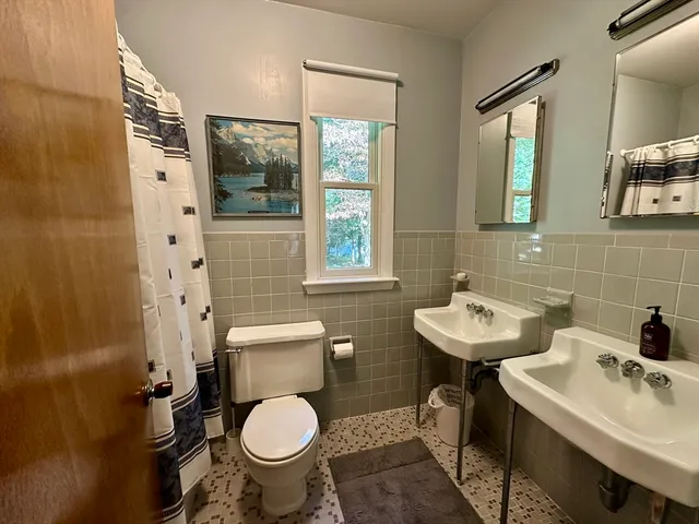 a bathroom with a toilet sink and mirror