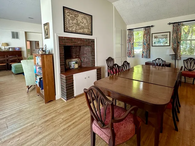 a dining room with furniture a fireplace and wooden floor