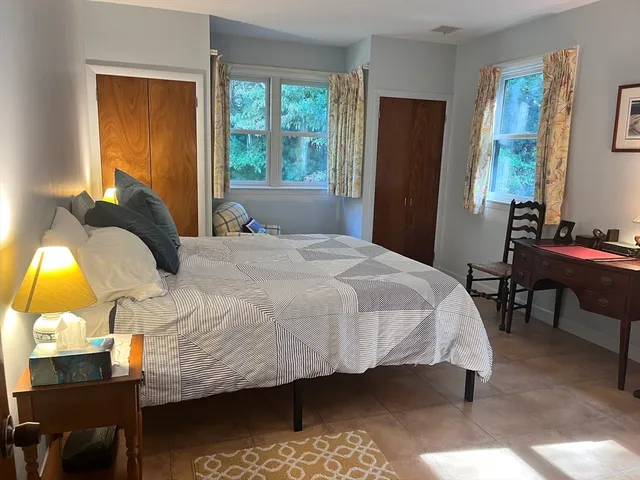 a bedroom with a bed lamp closet window and a table
