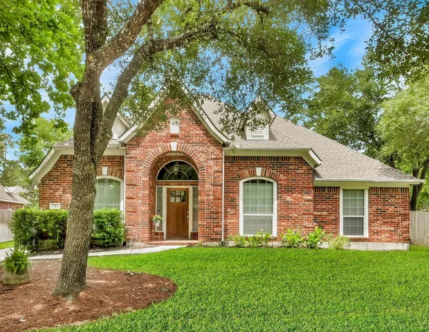 a front view of a house with a yard and potted plants