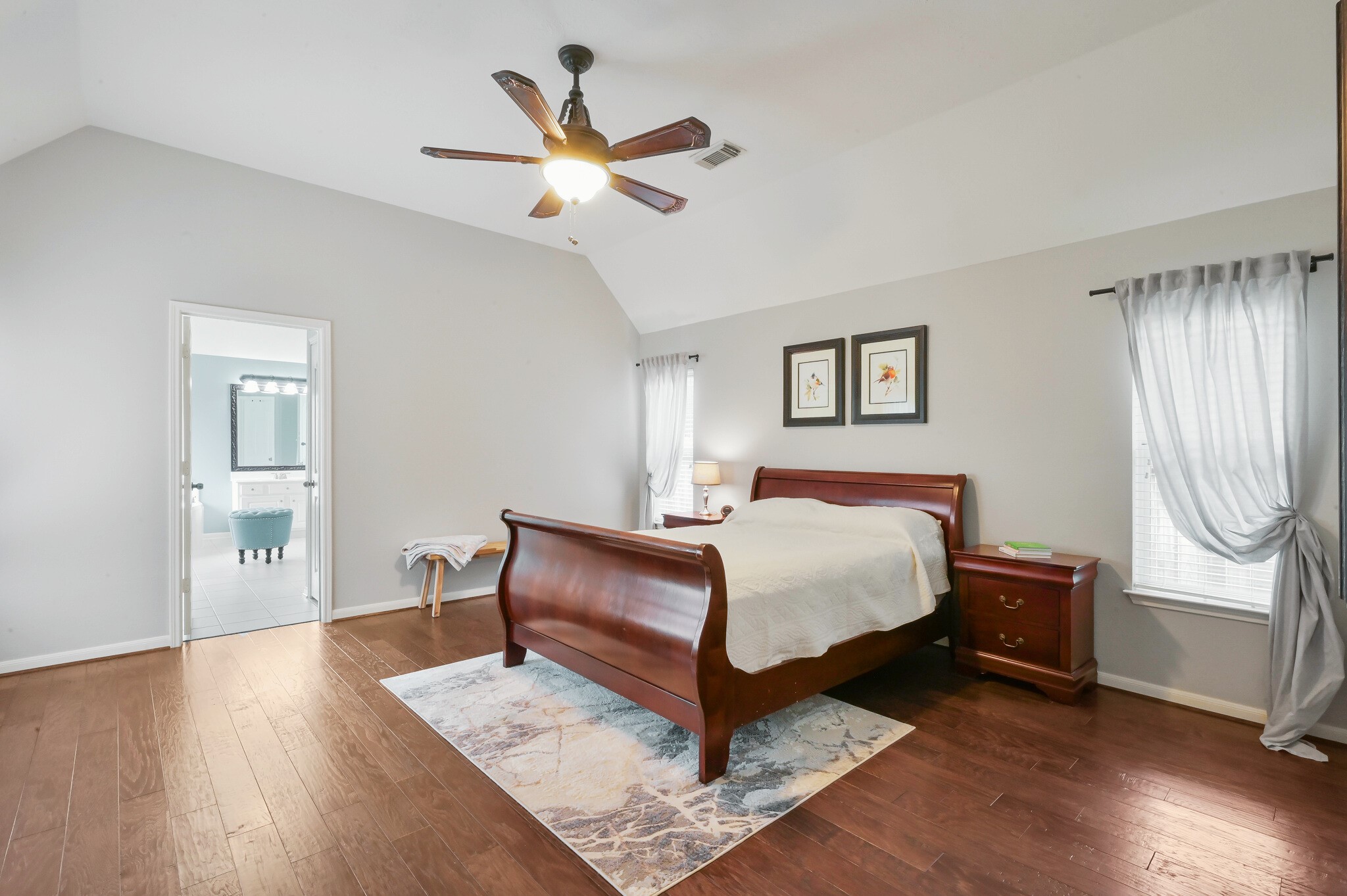 2 Westward Ridge Place The Woodlands, TX 77384 - Photo 23 of 43 The primary bedroom features a vaulted ceiling with a modern ceiling fan, hardwood floors and ample natural light from large windows