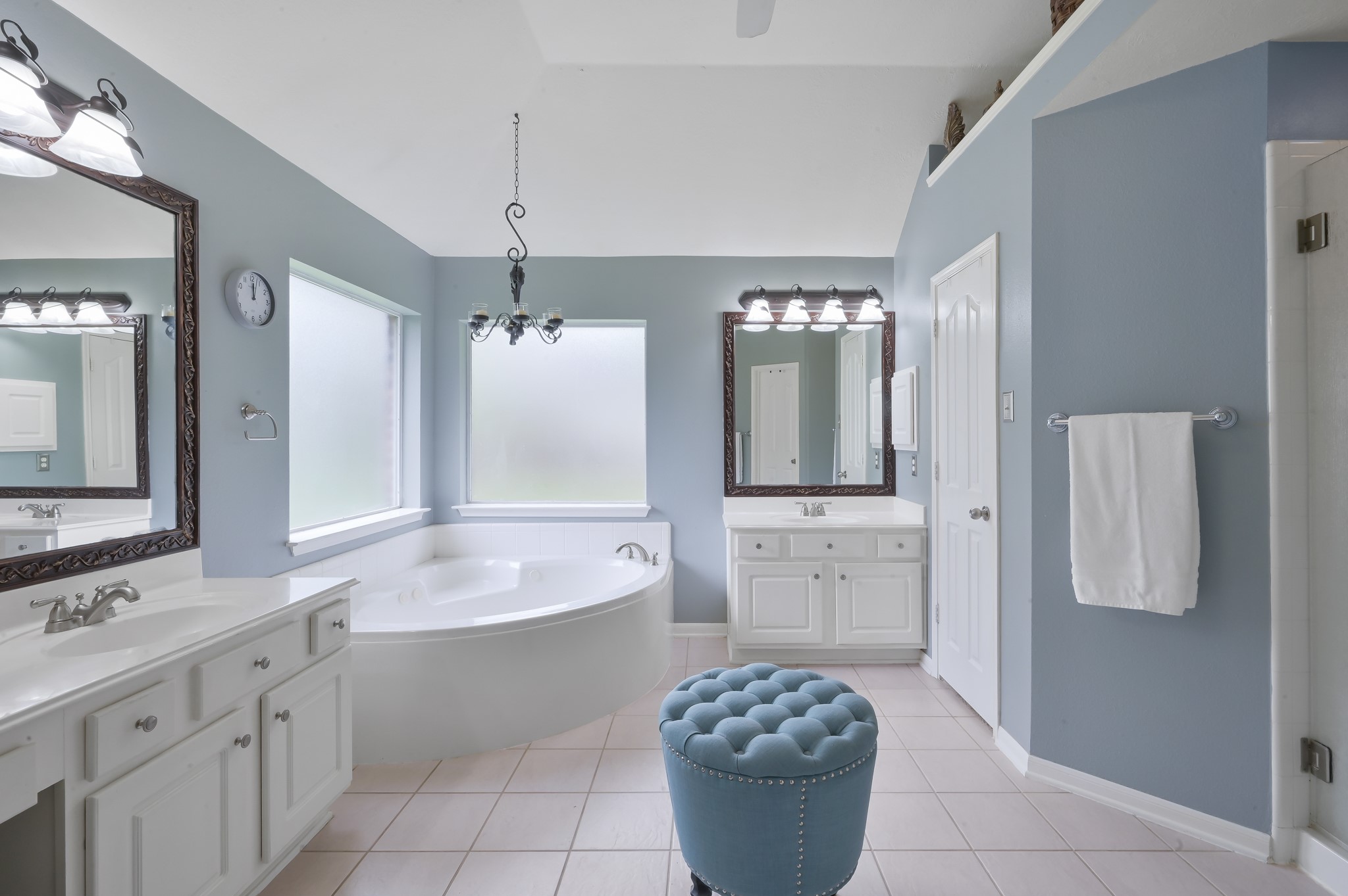 2 Westward Ridge Place The Woodlands, TX 77384 - Photo 25 of 43 The primary bath presents a soothing ambiance with its blue color scheme with a large soaking tub a separate frameless glass enclosed shower and white vanities.