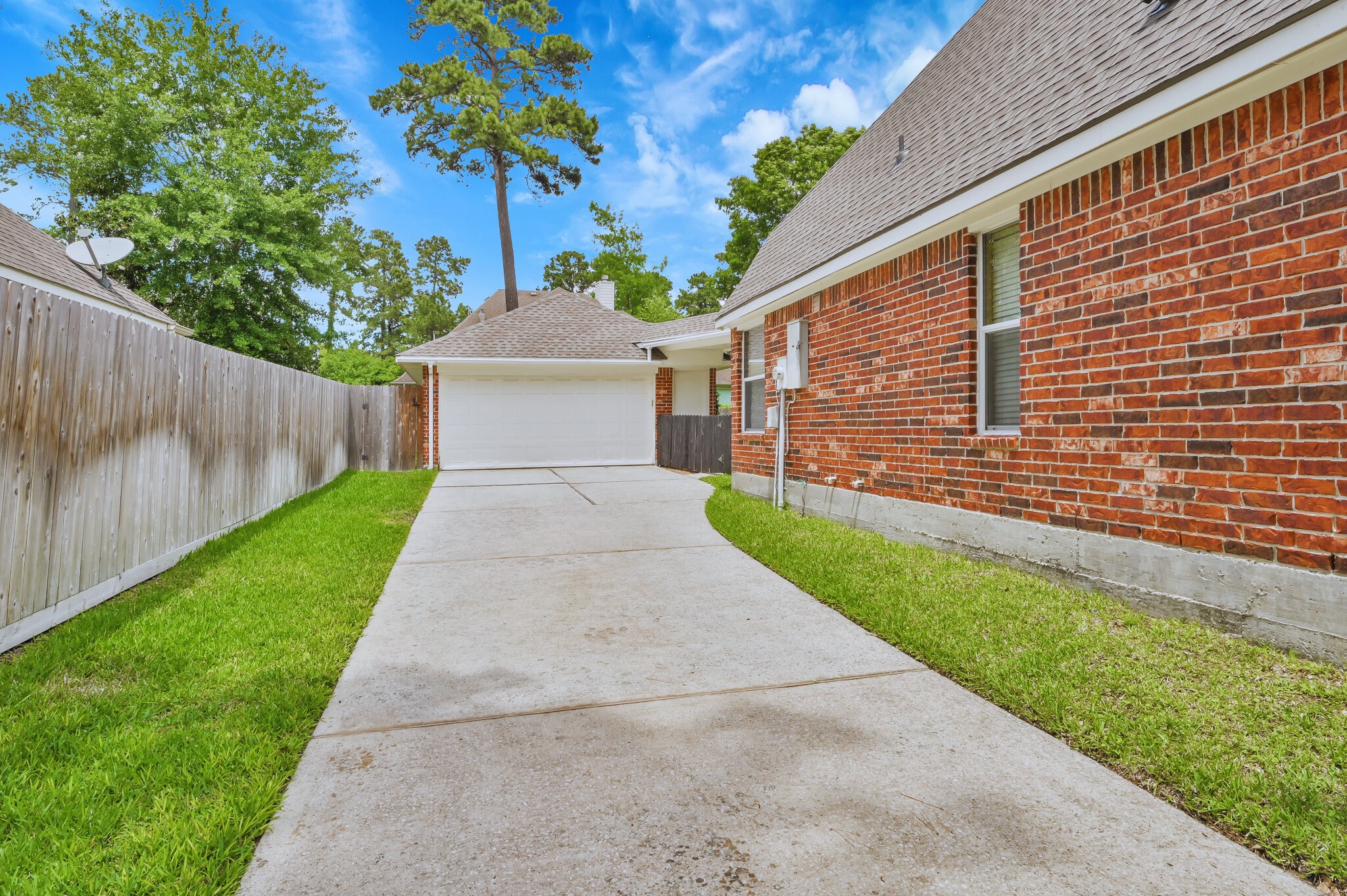2 Westward Ridge Place The Woodlands, TX 77384 - Photo 5 of 43 Behind the iron gate- Look at this long drive and tandem 3 car garage, extra/back side garage door for access to lawn equipment