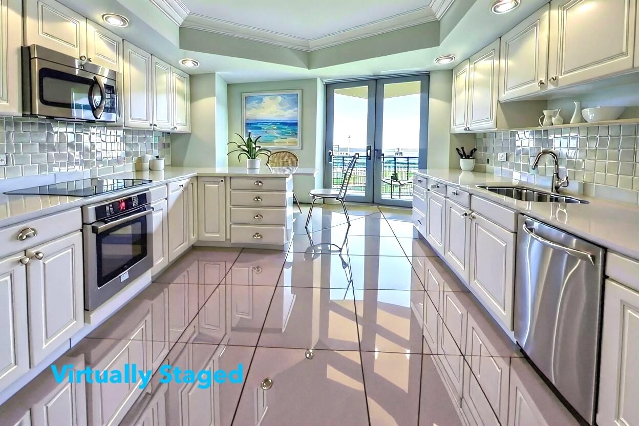 3322 Casseekey Island Road, Unit 504 Jupiter, FL 33477 - Photo 13 of 46 a kitchen with stainless steel appliances granite countertop a stove a sink and a microwave