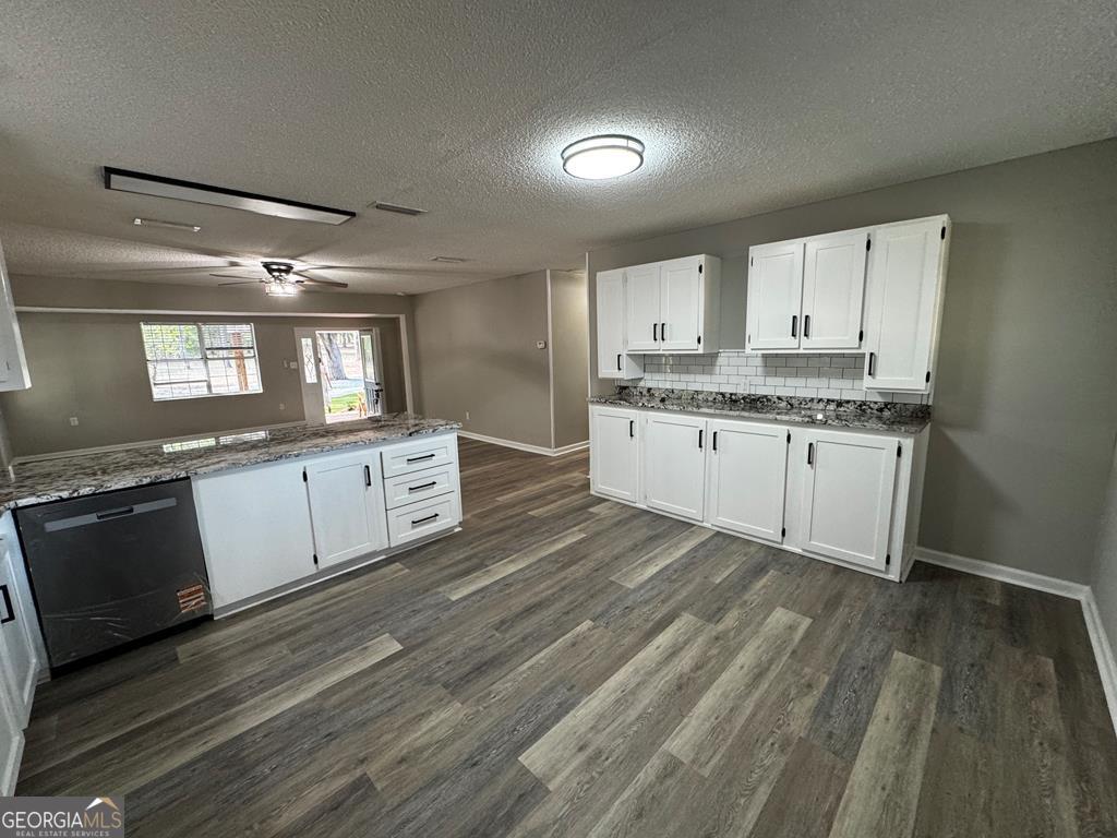 5781 Adams Road Valdosta, GA 31601 - Photo 18 of 27 a large kitchen with granite countertop a stove top oven a sink and dishwasher with wooden floor