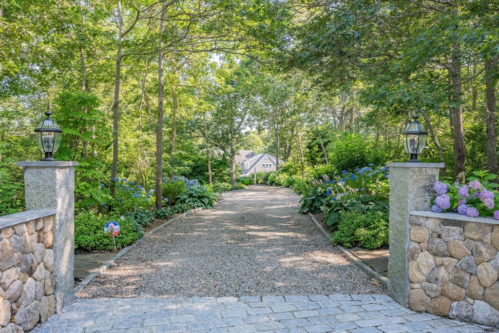 290 Old Comers Road Chatham, MA 02633 - Photo 33 of 40 a pathway of a house with potted plants and a fountain