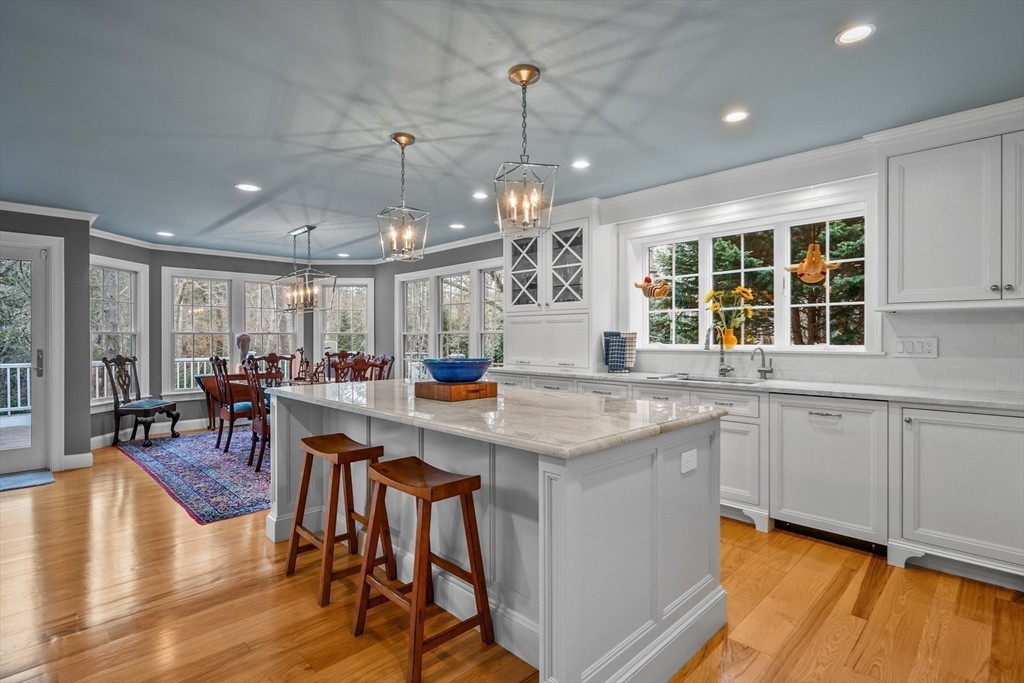 290 Old Comers Road Chatham, MA 02633 - Photo 9 of 40 a kitchen with center island dining table and wooden floor