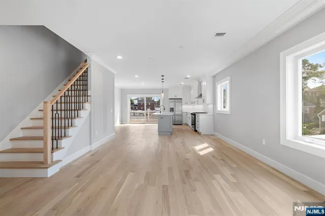 a view of a living room with wooden floor and windows