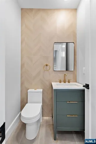 a bathroom with a toilet a sink and mirror