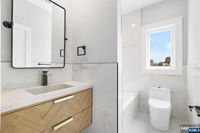a bathroom with a toilet sink and mirror