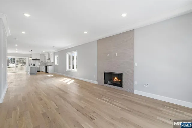 a view of empty room with wooden floor and a fireplace