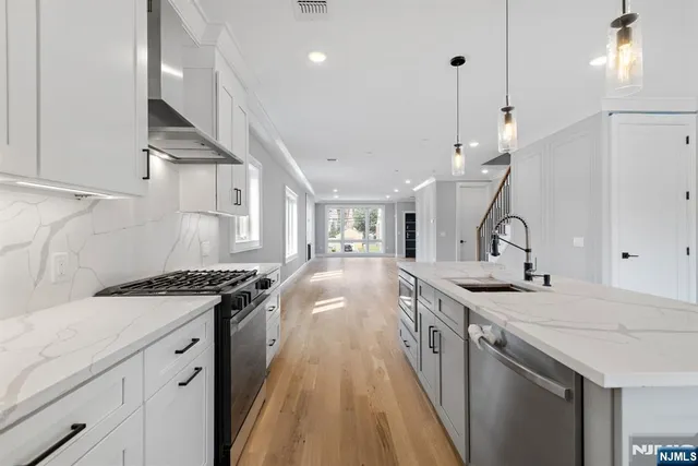 a kitchen with a sink a stove and chairs