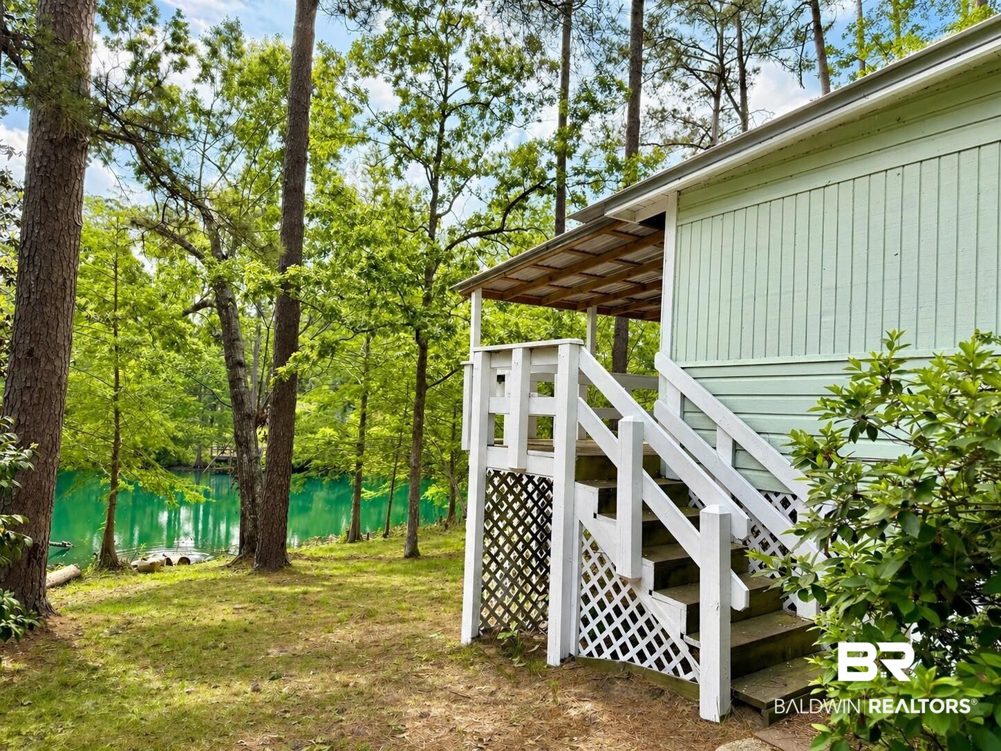 762 Buddy Lake Road Brewton, AL 36426 - Photo 6 of 20 Property exterior with light green siding, a covered deck, and white wooden stairs