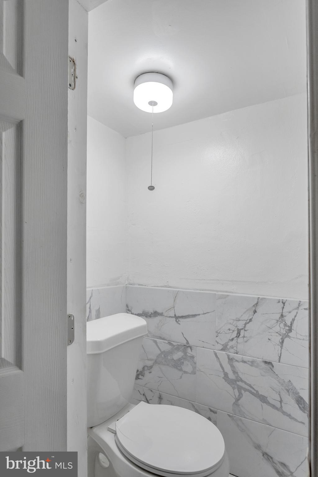 7249 Spruce Street Upper Darby, PA 19082 - Photo 25 of 30 a white toilet sitting next to a bathroom sink and vanity