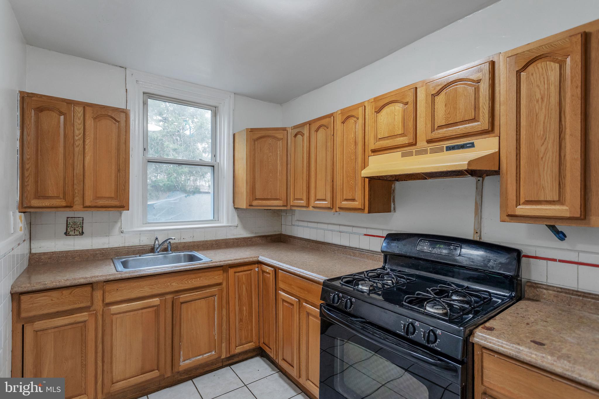 7249 Spruce Street Upper Darby, PA 19082 - Photo 8 of 30 a kitchen with granite countertop a stove sink and cabinets