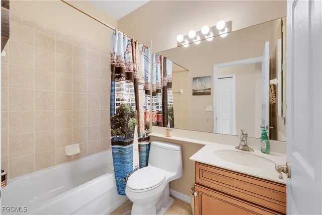 a bathroom with a sink a toilet a mirror a bathtub and shower