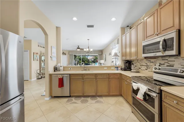 a large kitchen with stainless steel appliances granite countertop a stove sink and cabinets