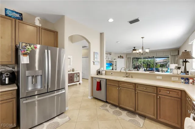 a large kitchen with stainless steel appliances granite countertop a refrigerator and a sink