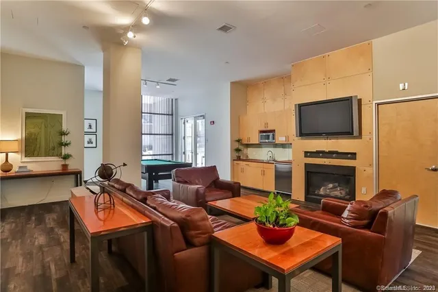 a living room with furniture a fireplace and a flat screen tv