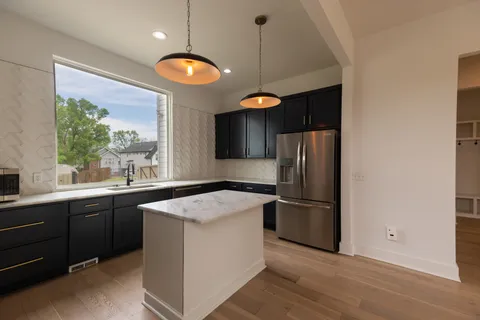 a kitchen with a sink a refrigerator and a stove top oven