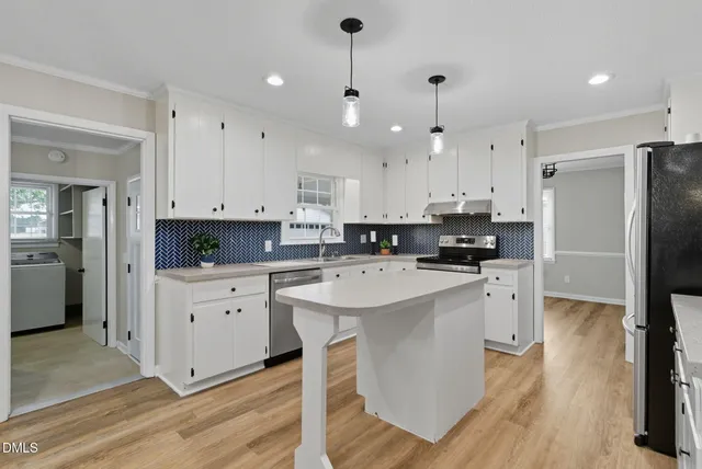 a kitchen with white cabinets and stainless steel appliances