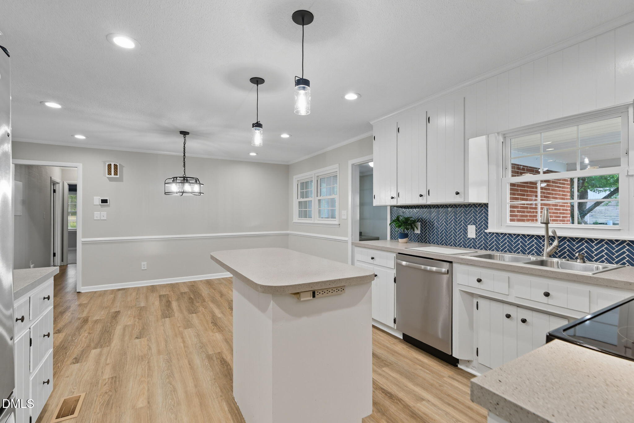 2238 Tarboro Road Youngsville, NC 27596 - Photo 15 of 41 a open kitchen with kitchen island a sink dishwasher a stove and white cabinets with wooden floor