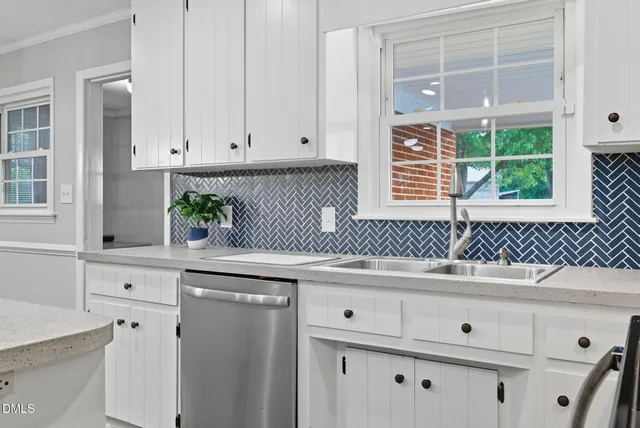 a kitchen with granite countertop white cabinets and a window