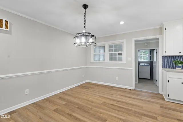 a view of empty room with wooden floor and stove