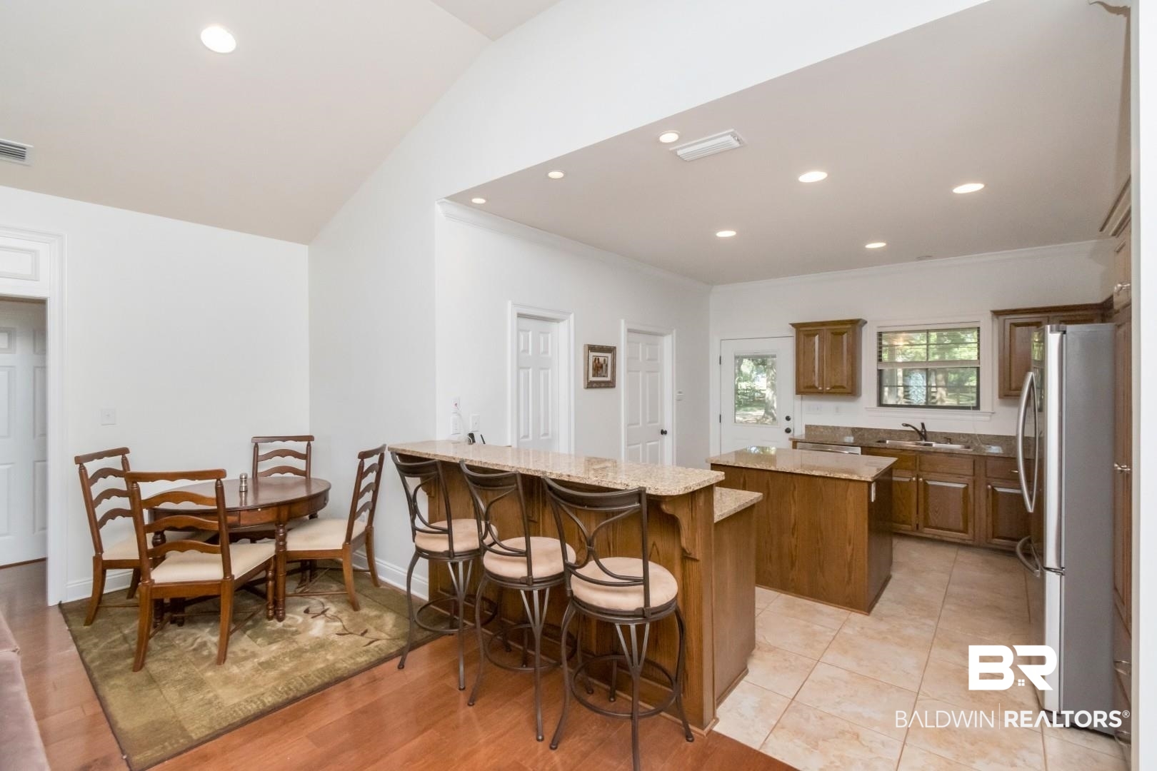 1360 Dykes Road North Mobile, AL 36608 - Photo 8 of 40 Kitchen featuring a center island, recessed lighting, a kitchen bar, freestanding refrigerator, and light stone countertops