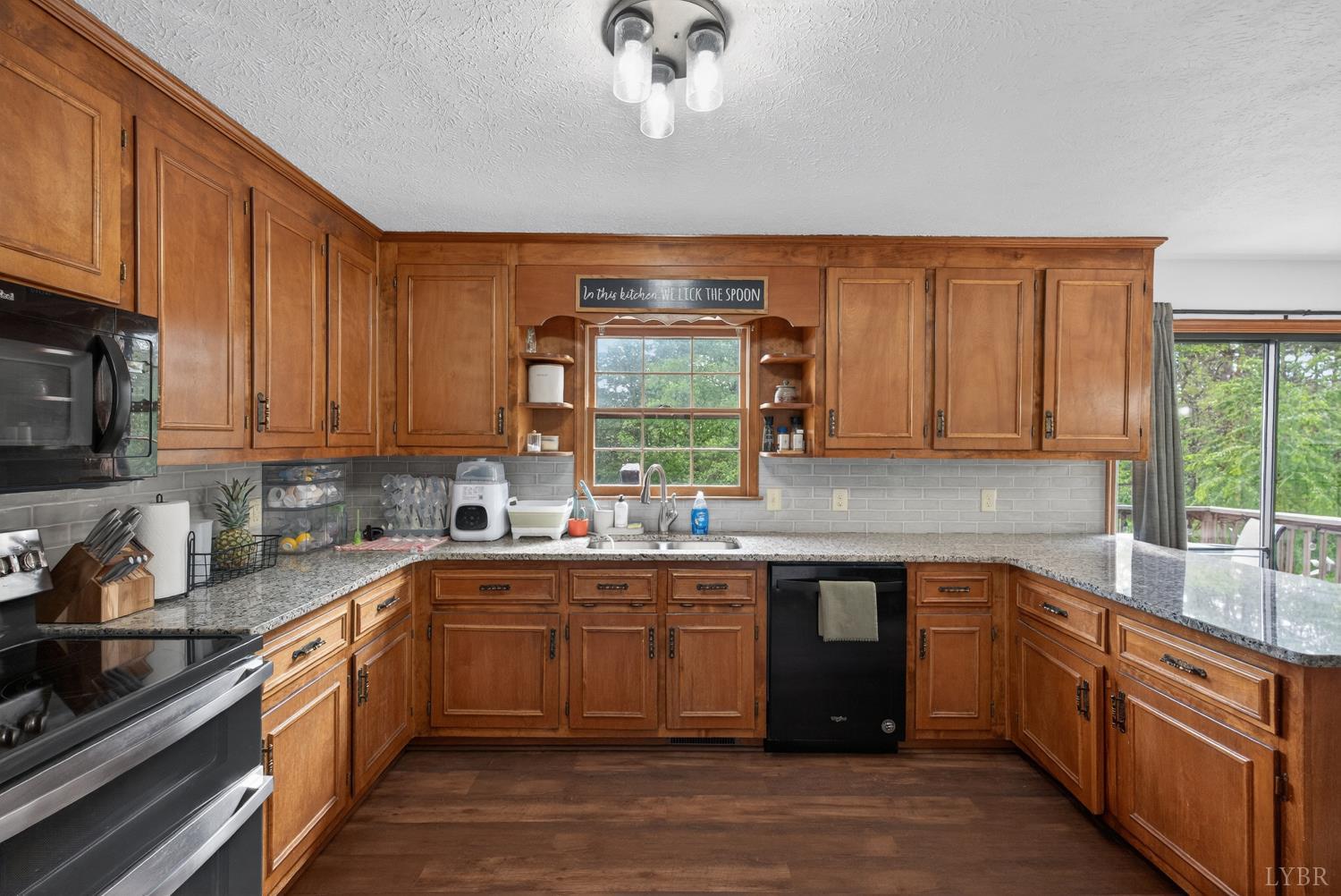 1002 Homeplace Road Rustburg, VA 24588 - Photo 16 of 48 a kitchen with kitchen island granite countertop a sink window and cabinets