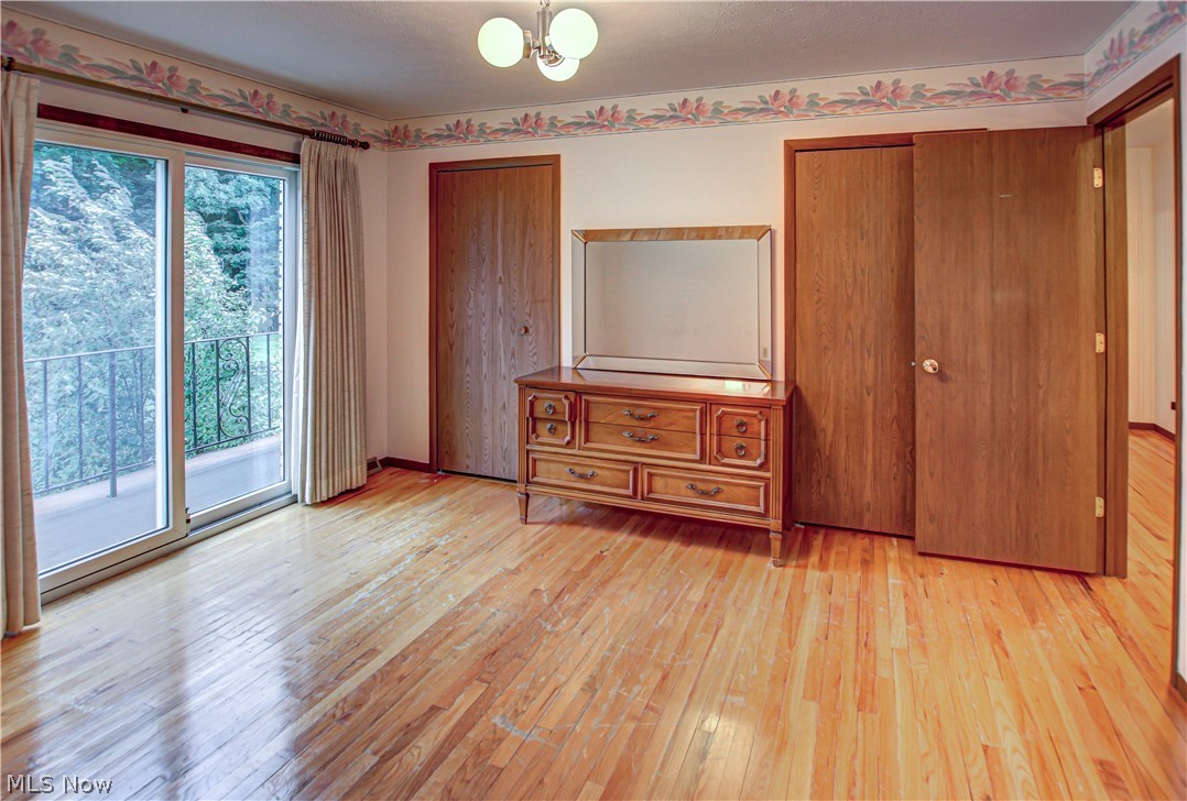 6013 Rousseau Drive Parma, OH 44129 - Photo 26 of 50 Unfurnished bedroom featuring an inviting chandelier, access to outside, light wood-type flooring, and multiple windows