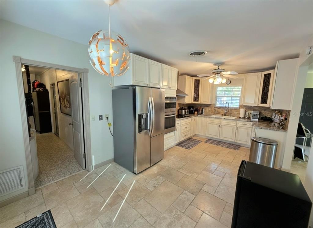 6736 Ralston Beach Circle Tampa, FL 33614 - Photo 12 of 37 a kitchen with stainless steel appliances granite countertop a refrigerator and a stove top oven