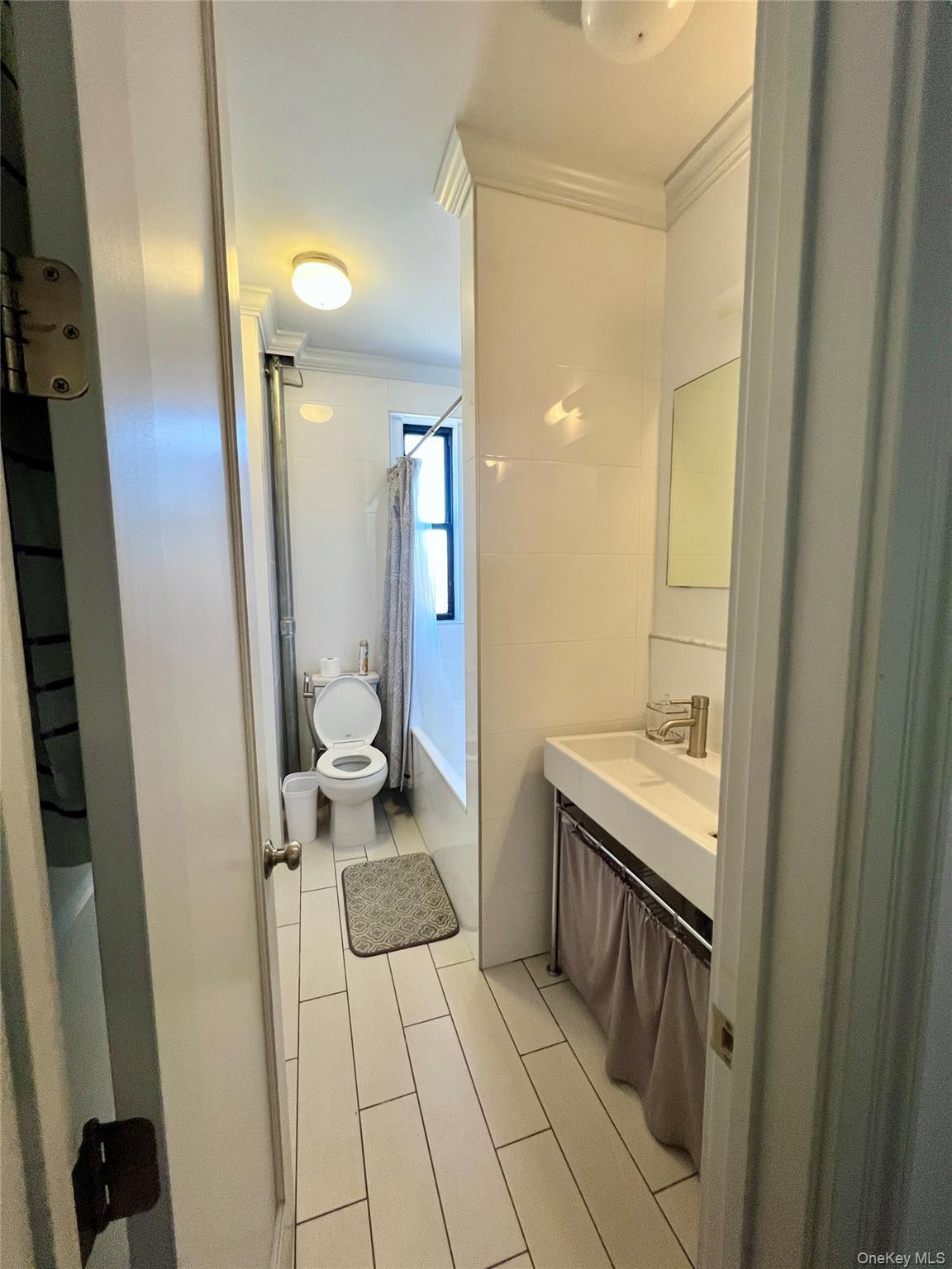 42-22 Ketcham Street, Unit F16 Queens, NY 11373 - Photo 11 of 17 a bathroom with a sink and a mirror