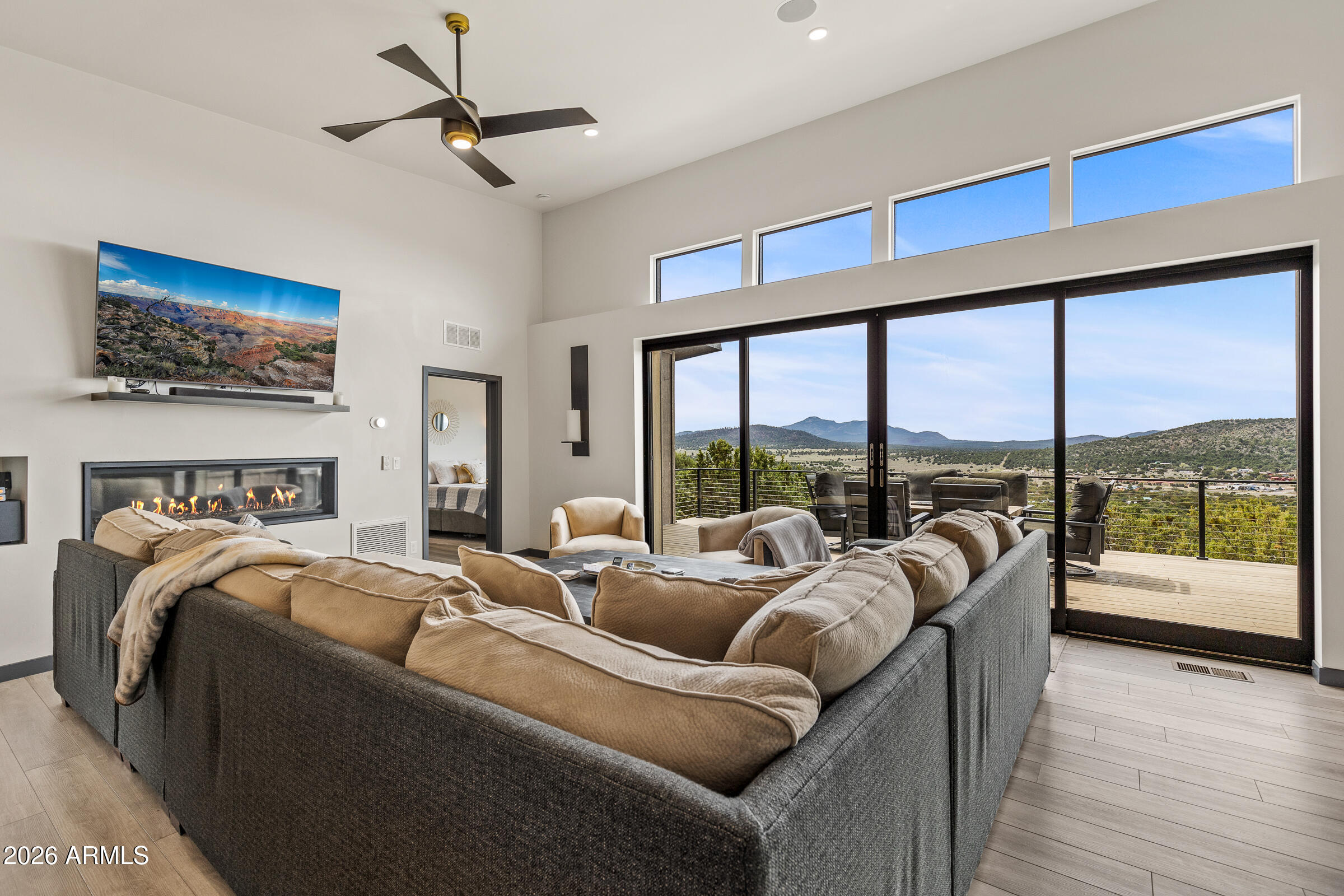 a living room with furniture a ceiling fan and a floor to ceiling window