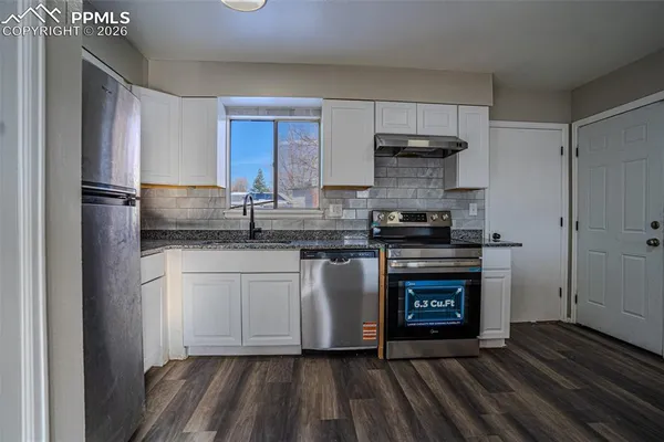 a kitchen with stainless steel appliances granite countertop a stove a refrigerator and a microwave
