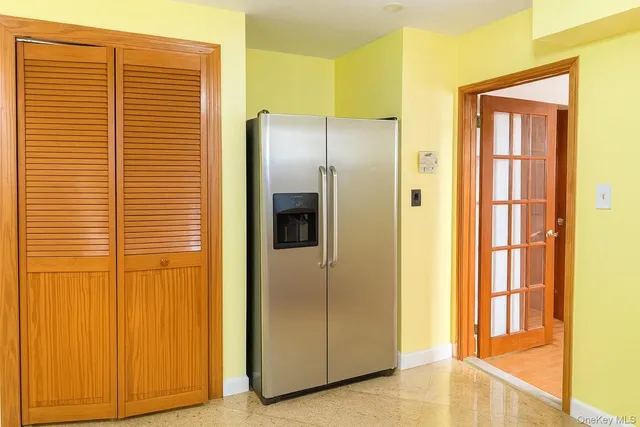 an empty room with a window and a chandelier fan